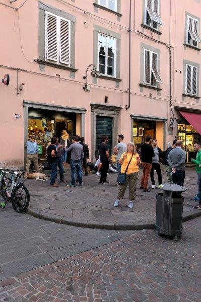 Susan having a beer on the sidewalk in Lucca