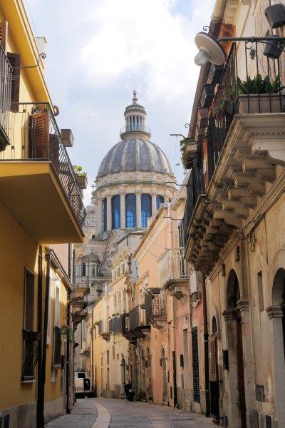 Duomo dome above the buildings in the narrow street